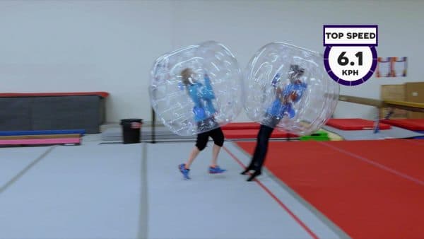 woman in a bubble suit demonstrates a collision with a man in a bubble suit