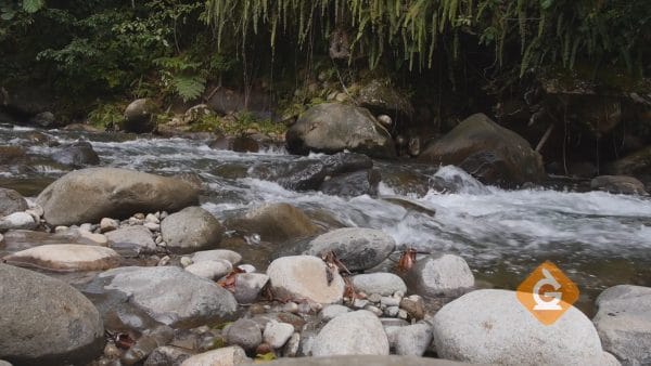 water flows by rocks representing the hydrosphere