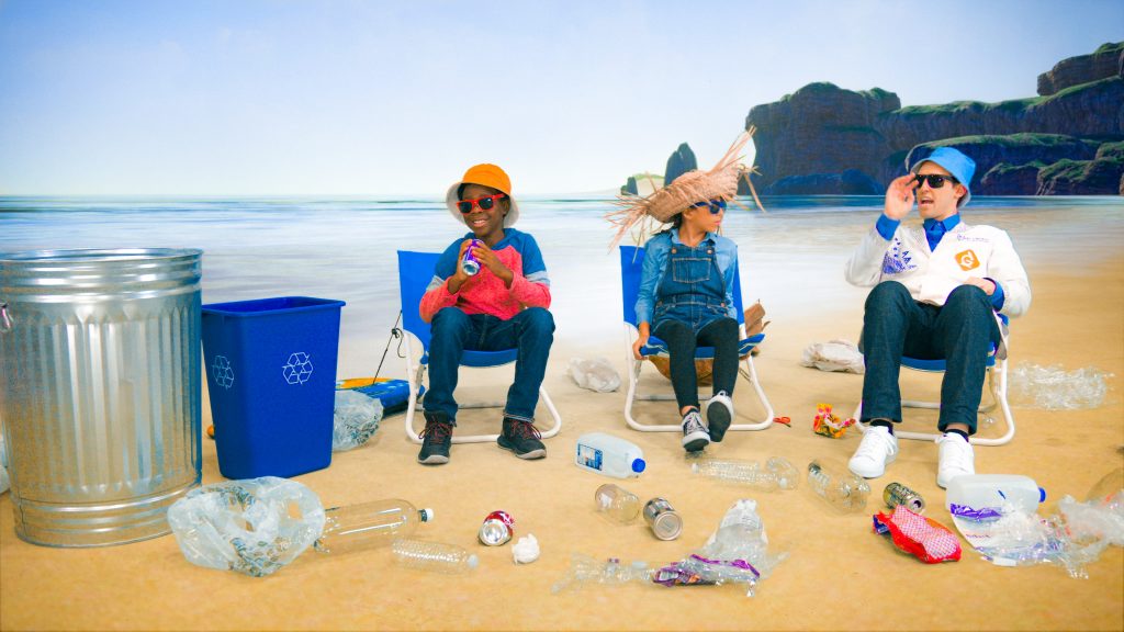 people sitting on a beach with trash around them