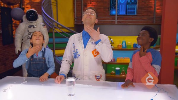 scientist and kids hum to feel the sound vibrations in their vocal cords
