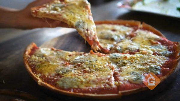 delicious pizza with a hand taking one slice